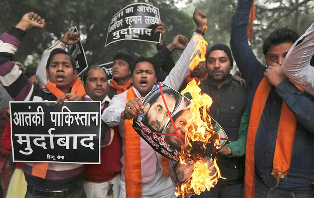 A small group of rightwing activists of the Hindu Sena or the Hindu Army burn posters with portraits of Pakistani Prime Minister Nawaz Sharif and Zaki-ur-Rehman Lakhvi, the chief suspect in the Mumbai attack trial, near the residence of Pakistan High commissioner to India in New Delhi.