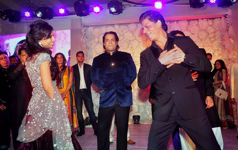 Sharukh Khan dances at the Sangeet Ceremony of Shirin Morani (L) and Uday Singh (C) in Mumbai.