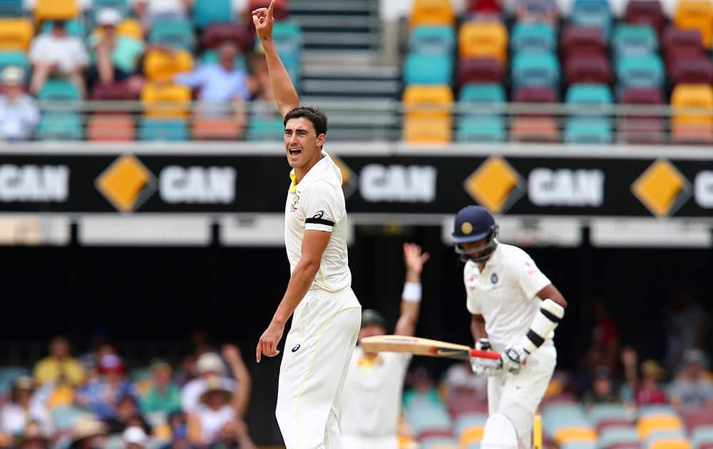 Australia's Mitchell Starc, celebrates after getting the wicket of Ravichandaran Ashwin, during their play on day four of the second cricket test in Brisbane, Australia.