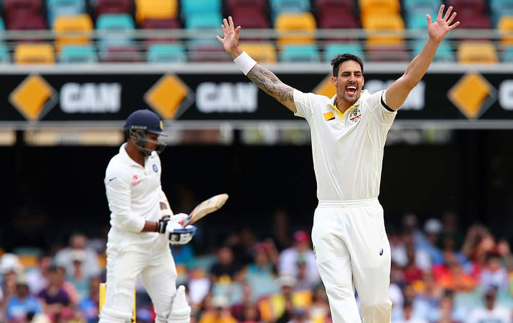 Mitchell Johnson, celebrates after he got the wicket of  Umesh Yadav during their play on day four of the second cricket test in Brisbane.