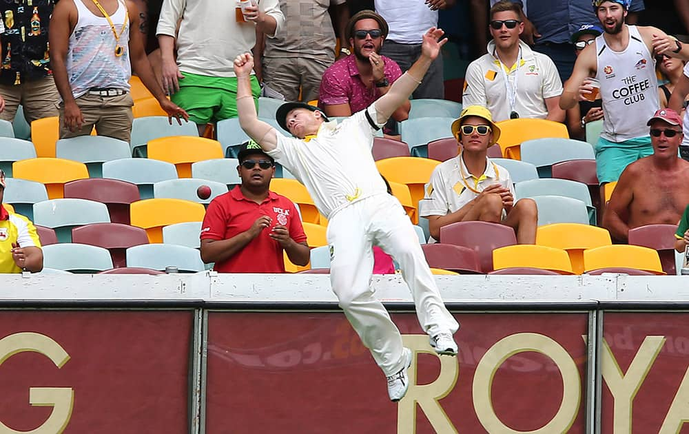 David Warner dives over the boundary rope trying to take a catch during their play on day four of the second cricket test in Brisbane.