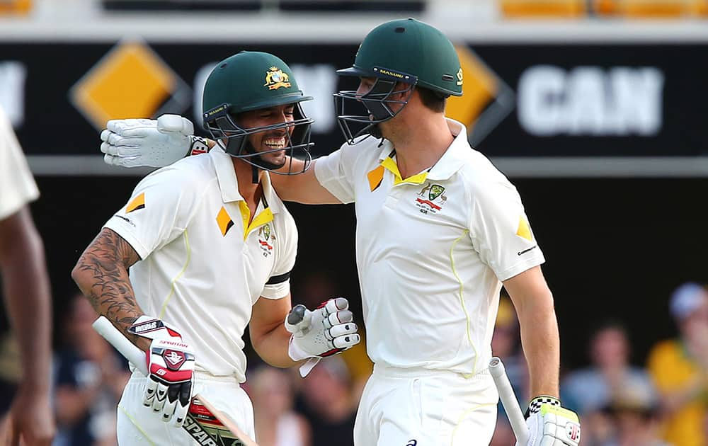 Mitchell Johnson and Mitchell Marsh celebrate victory on day four of the second cricket test between Australia and India in Brisbane.