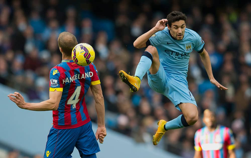 Manchester City's Jesus Navas, right, fights for the ball against Crystal Palace's Brede Hangeland during the English Premier League soccer match between Manchester City and Crystal Palace at the Etihad Stadium, Manchester, England.