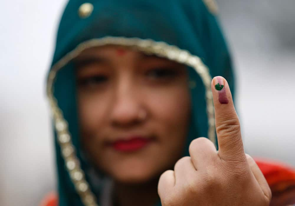 A woman displays the indelible ink mark on her finger after casting her vote during the fifth phase of voting, at Satrayan village near the India-Pakistan international border, about 32 kilometers from Jammu, India.