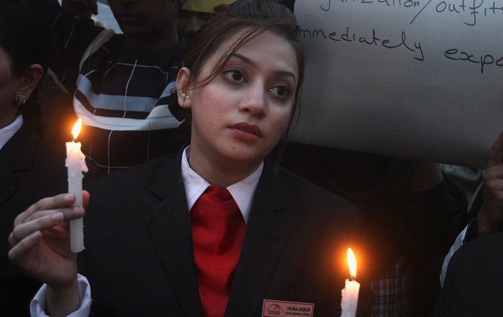 A Pakistani student holds a candle during a vigil to pay tribute to the victims killed in Tuesdays Taliban attack on a military-run school in Peshawar.