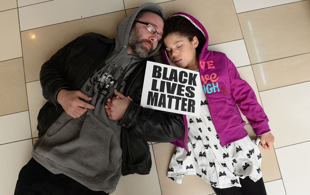 Shane Quandt, of Albany, holds hands with his girlfriend's 9-year-old daughter, Mina Vrooman, as protestors staged a 