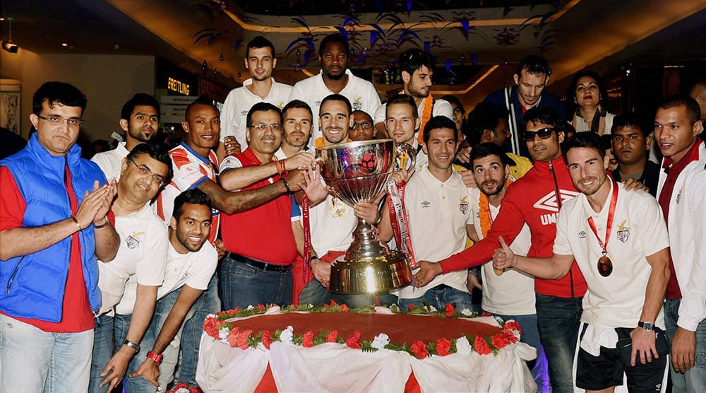 Players of Atletico De Kolkata Football team alongwith with teams their co-owners, Sourav Ganguly, Sanjiv Goenka poses with the Trophy after they arrive in Kolkata.