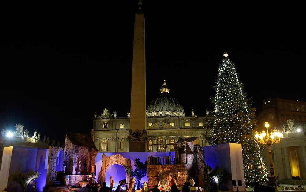 The 25.5 meters (83.66 ft), 70-year old Christmas tree and the Nativity scene are lit in St. Peter's square at the Vatican.