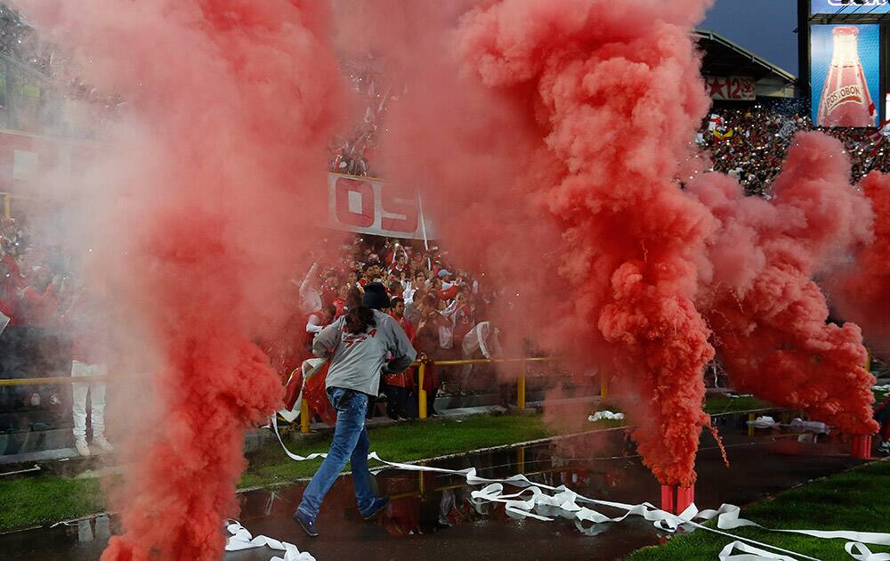 Fans of Santa Fe cheer their team during the Colombian soccer league final game against Deportivo Independiente Medellin in Bogota, Colombia.