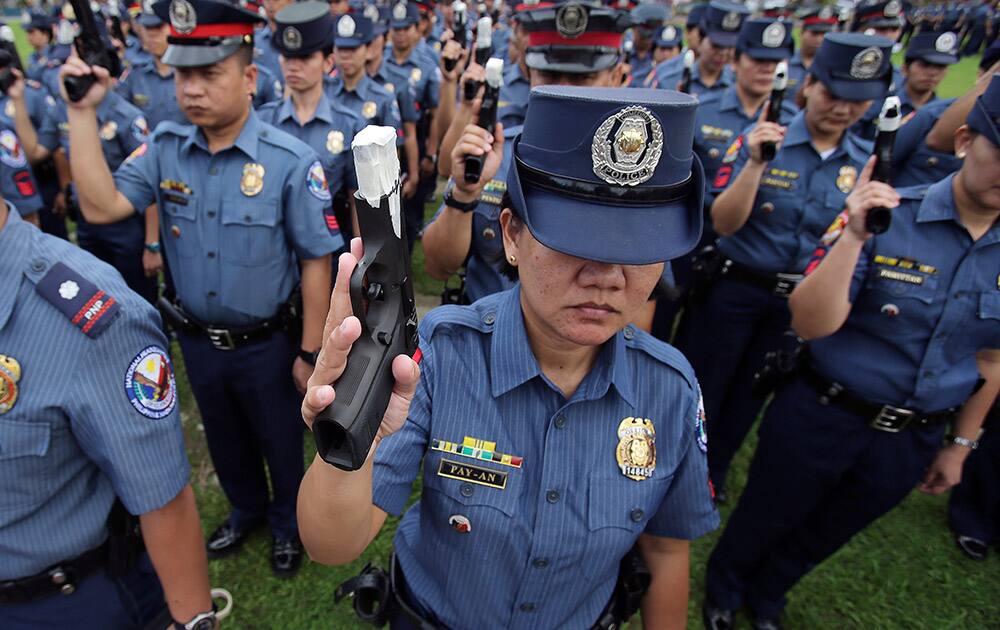 Philippine police show their pistols that were taped at the muzzle at Camp Crame in suburban Quezon City, north of Manila, Philippines. Police were ordered to have their firearms tapped and signed by their leaders to prevent them from firing during the Christmas and New Year revelry. Firing of guns in the air during the celebrations has led to numerous deaths from stray bullets in the past. 