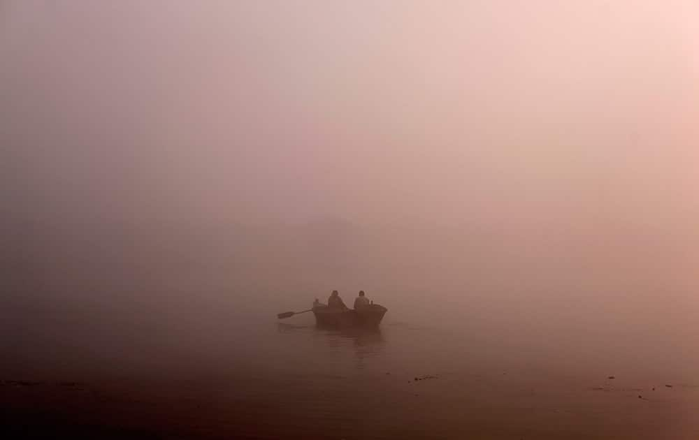 A man rows his boat on the River Ganges in the early morning fog on the outskirts of Allahabad.