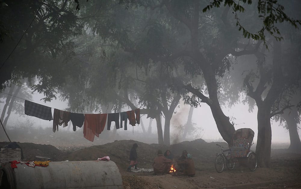 An Indian family warms itself around a fire on a cold morning, at Allahabad, India, Monday.