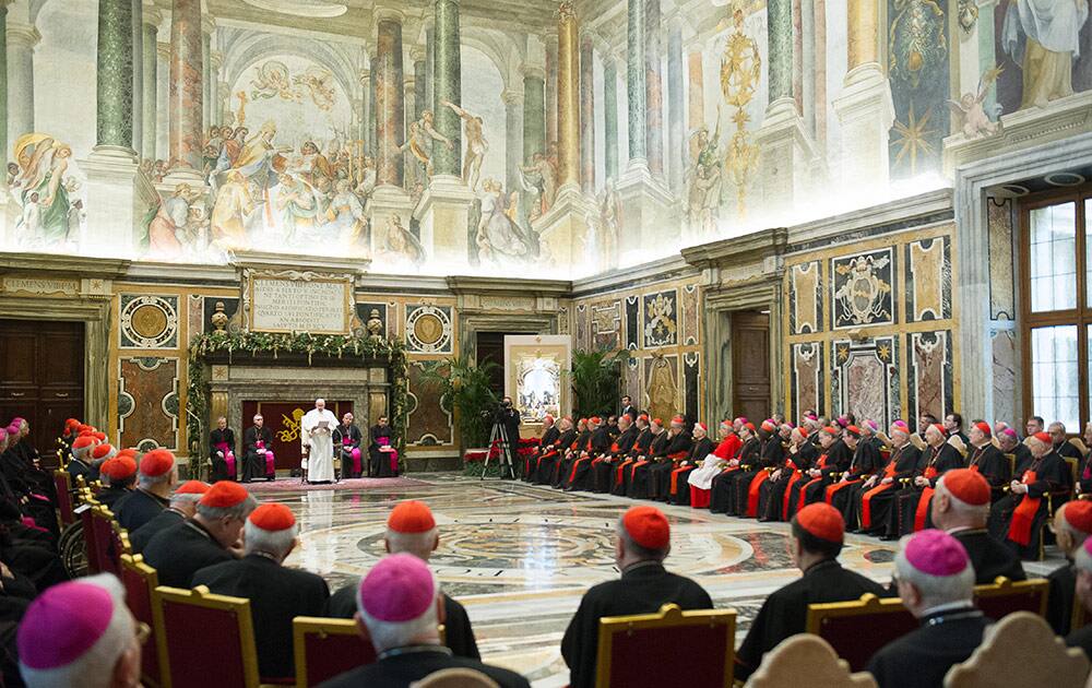 In this picture made available by the Vatican newspaper L' Osservatore Romano, Pope Francis, background center, delivers his message during a meeting with Cardinals and Bishops of the Vatican Curia on the occasion of the exchange of Christmas greetings in the Clementine hall at Vatican, Monday.