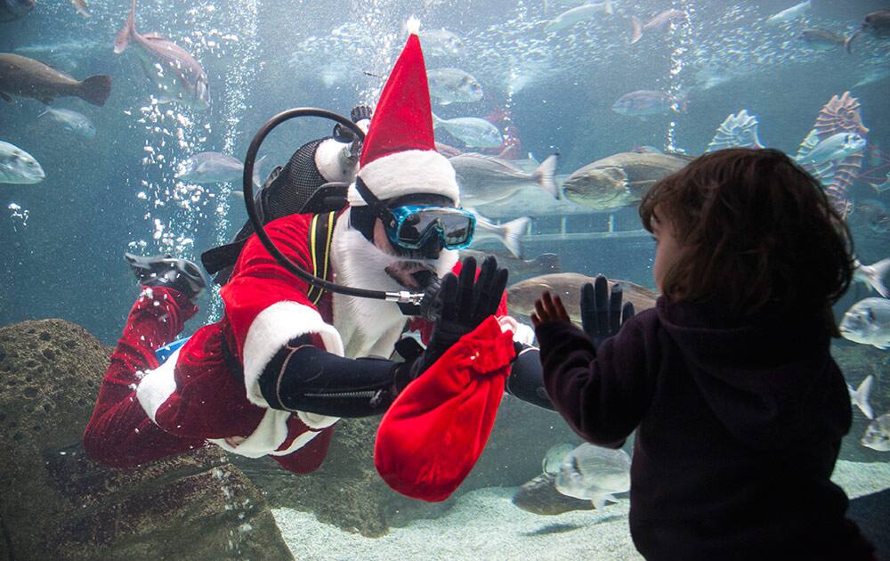 A diver dressed as Santa Claus waves at a child at the Creta Aquarium in the town of Hersonissos, on the Greek island of Crete, Monday.