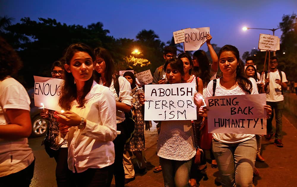 India students hold placards and candles as they participate in a candle march held in memory of Pakistani victims killed in a Taliban attack on a military-run school in Peshawar, in Mumbai, India, Monday.