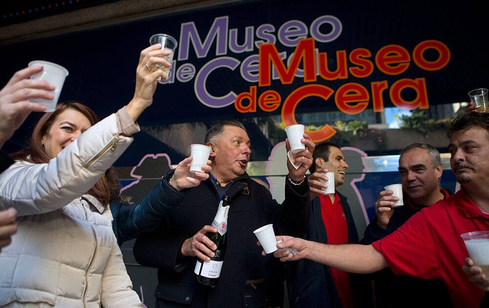 Gonzalo Presa, centre and other workers from the Wax Museum celebrate after they won the main Christmas lottery prize in Madrid, Spain, Monday.