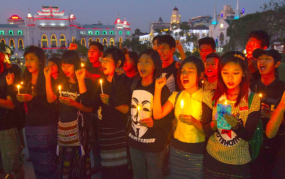 Activists holding candles offer prayers for a victim who was killed during a crackdown on protesters at a copper mine in northwestern Myanmar.