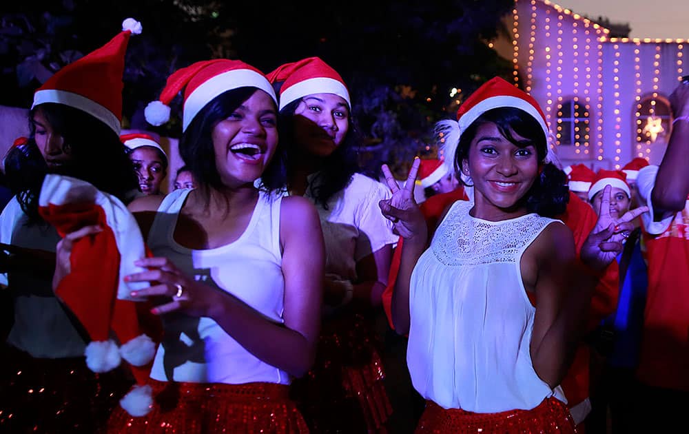 Indian girls wear Santa Claus hats and pose for a photograph during a Christmas carnival in Mumbai.