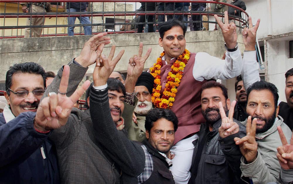 BJP candidate Gagan Bhagat with his supporters flash victory sign after won from R S Pura constituency in Jammu.