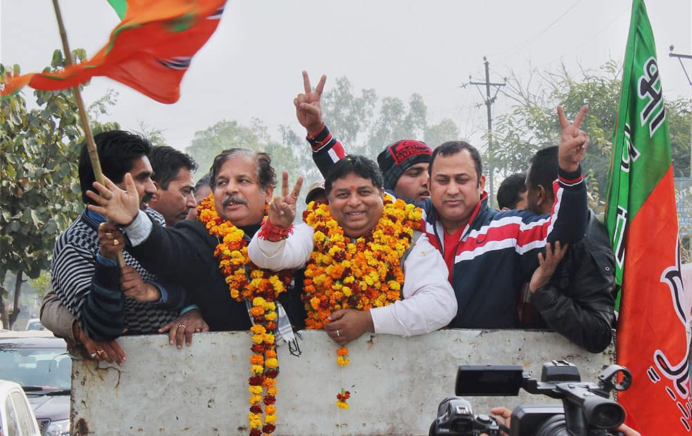 BJP candidate Sat Paul Sharma flashes victory sign after his win from Jammu West Constituency, in Jammu.