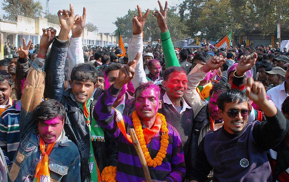 BJP supporters flash victory sign as they celebrate their party's win in Jharkhand Assembly polls in Ranchi.