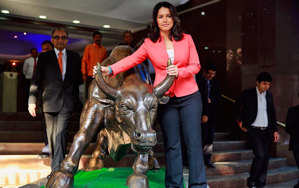 US Congresswoman Tulsi Gabbard, D-Hawaii, poses with a cast of a bronze bull, the symbol of the Bombay Stock Exchange (BSE), during an event in Mumbai. Gabbard, the first Hindu elected to Congress, is on an official visit to India. 