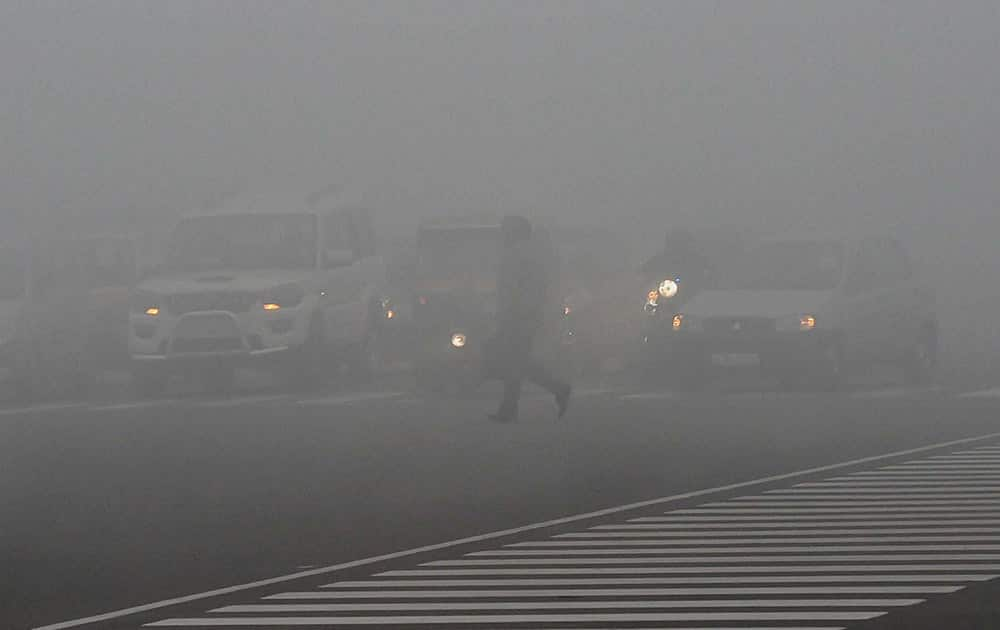 People move in heavy fog in New Delhi.