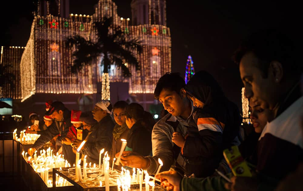 Christians light candles at a Sacred Heart Cathedral on the eve of Christmas in New Delhi.