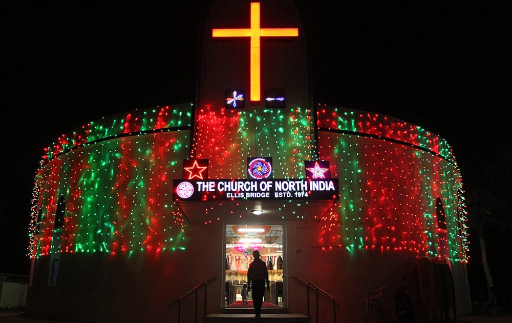 A man exits an illuminated Church on Christmas Eve in Ahmadabad.