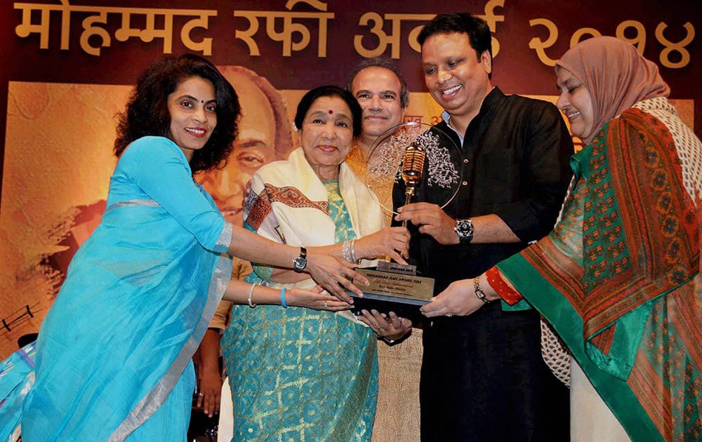 Bollywood singer Asha Bhosle receives award on the occasion of Mohd. Rafis birth anniversary, in Mumbai.