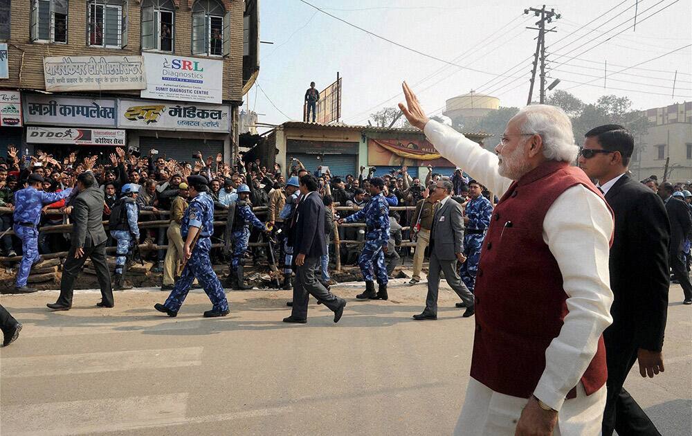 Prime Minister Narendra Modi greets people on the streets of Varanasi.