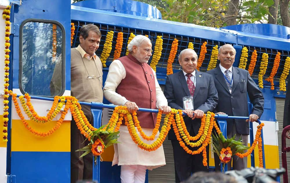 Prime Minister Narendra Modi with Union Minister for Railways Suresh Prabhakar Prabhu and Chairman of Railway Board Arunendra Kumar on the new high horsepower diesel locomotive, at Diesel Locomotive Works (DLW), in Varanasi.