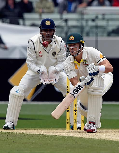 MS Dhoni, watches on as Australia's Shane Watson bats during their play on day one of the third cricket test in Melbourne, Australia.