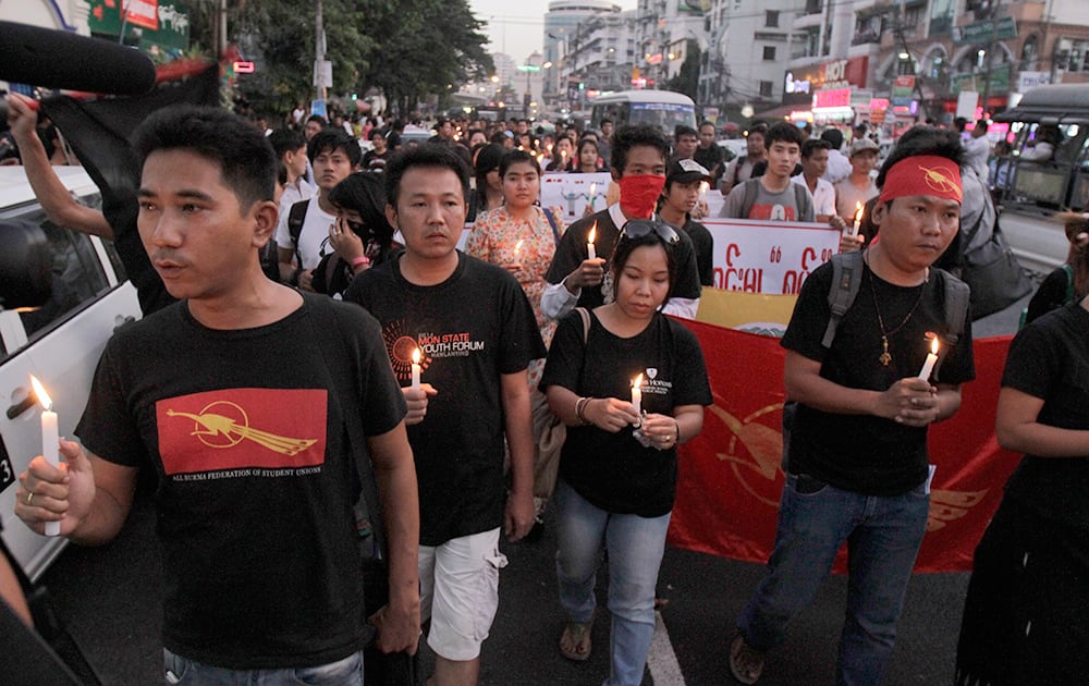 Student activists hold candles, as they offer prayer for a victim who was killed during a recent crackdown on protesters at a copper mine in northwestern Myanmar.