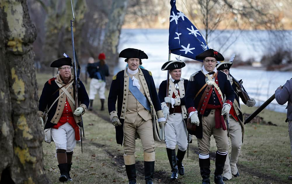 George Washington, played by John Godzieba, walks with troops near the Delaware River during the 62nd annual reenactment of Washington's daring Christmas 1776 crossing of the river - the trek that turned the tide of the Revolutionary War, in Washington Crossing, Pa.