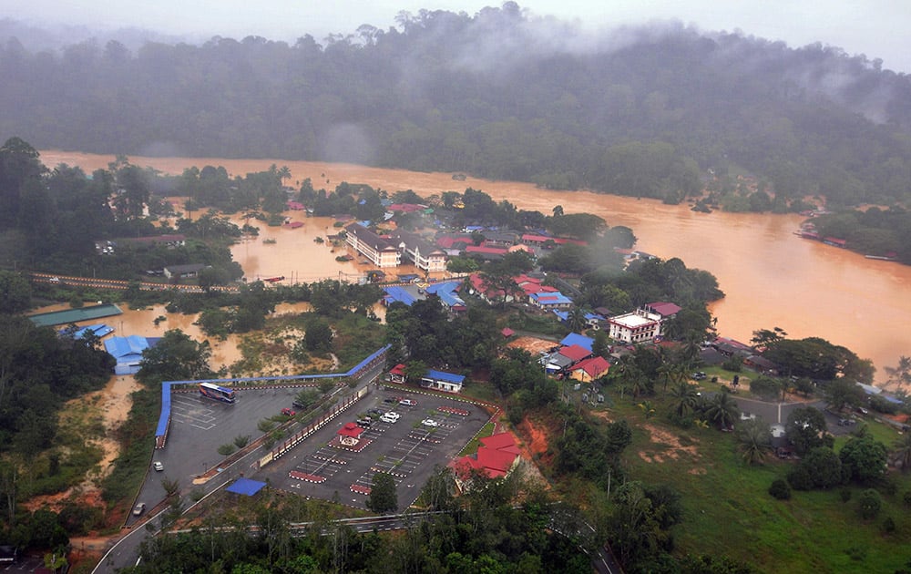 Numbers of houses and buildings along a flooded river stand in muddy water in Malaysia National Park in Kuala Tahan, Pahang state, Malaysia.