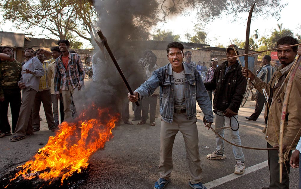 Tribal people burn tires to block a national highway during a twelve-hour general strike in Biswanath Chariali in Assam.