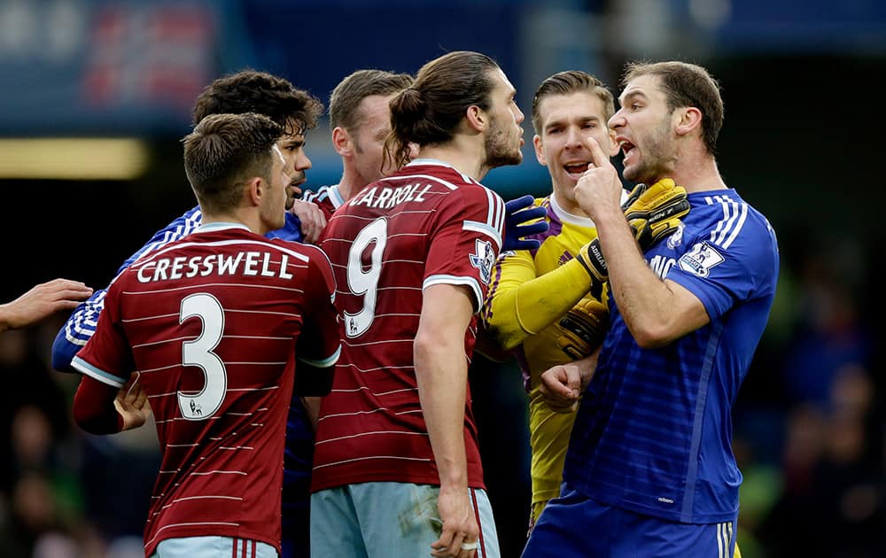 Chelsea's Branislav Ivanovic, right, argues with West Ham United's Andy Carroll, second right, as he is pushed back by goalkeeper Adrian during the English Premier League soccer match between Chelsea and West Ham at Stamford Bridge stadium in London.