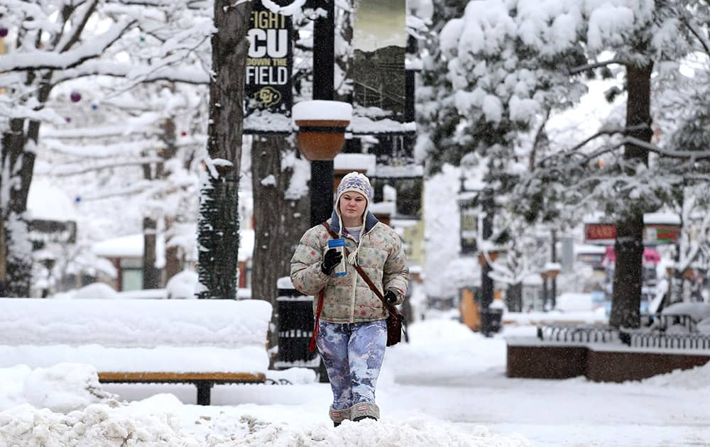 Alexa Hight of Longmont takes a stroll on the Pearl St. Mall after showing up too early for work, amid fresh snow in Boulder, Colo.