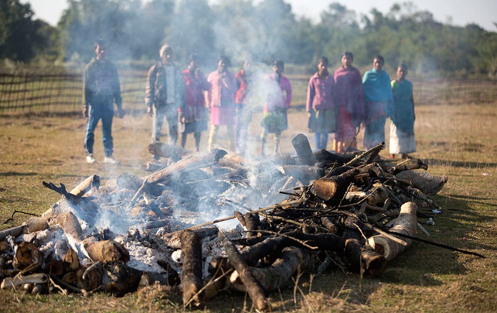 Tribal people watch mass cremation of villagers who were killed during an attack by an indigenous separatist group, in a field near a relief camp at Tinsuti village in Sonitpur district of Indian eastern state of Assam.