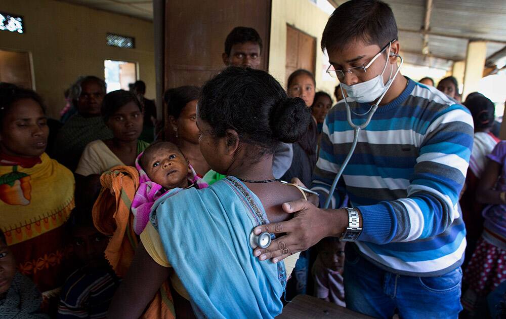 A government doctor checks a tribal woman at a camp in Shamukjuli village in Sonitpur district of Indian eastern state of Assam.