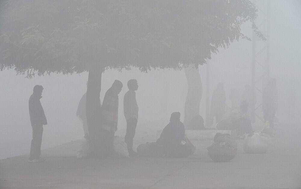 People wait for train on a dense fog.