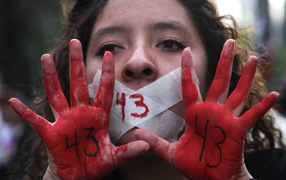 A woman holds up her red-painted hands and the number 43 written on them to remember the 43 missing students from the Isidro Burgos rural teachers college during a protest in Mexico City.