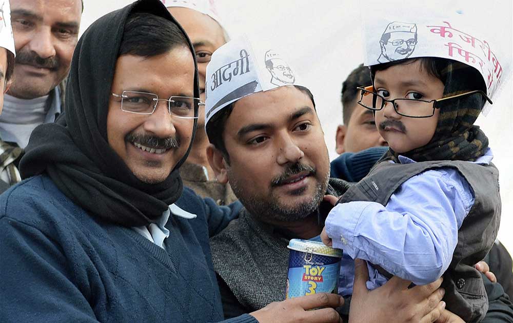 A kid resembling Aam Aadmi Party convener Arvind Kejriwal, gives his piggy bank during fund-raising campaign- Coffee with Kejriwal in New Delhi.