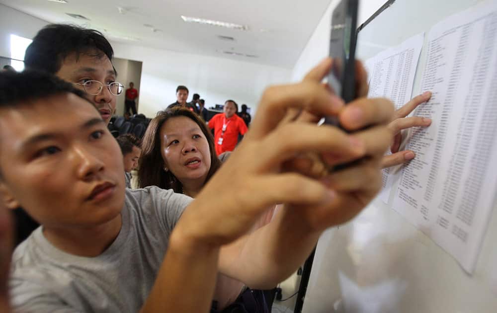 Relatives of the passengers onboard AirAsia flight QZ8501, check the plane's manifest at a crisis center set up by local authority at Juanda International Airport in Surabaya, East Java, Indonesia.