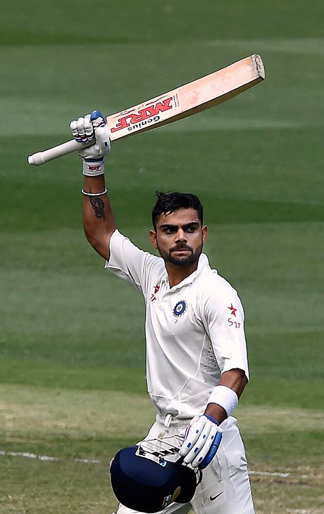 India's Virat Kohli raises his bat as he celebrates making 100 runs against Australia on the third day of their cricket test match in Melbourne, Australia.