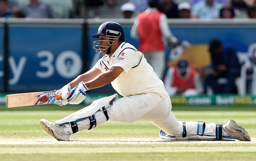 India's MS Dhoni stretches out to play a sweep against Australia on the third day of their cricket test match against Australia in Melbourne, Australia.