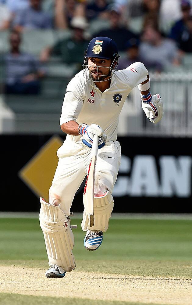 India's Virat Kohli runs between the stumps on the third day of their cricket test match against Australia Melbourne, Australia, Sunday.