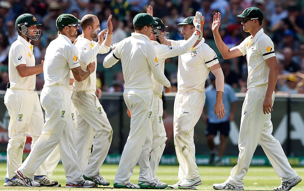 Australian teammates celebrate the wicket of India's Lokesh Rahul for 3 runs on the third day of their cricket test match in Melbourne, Australia.