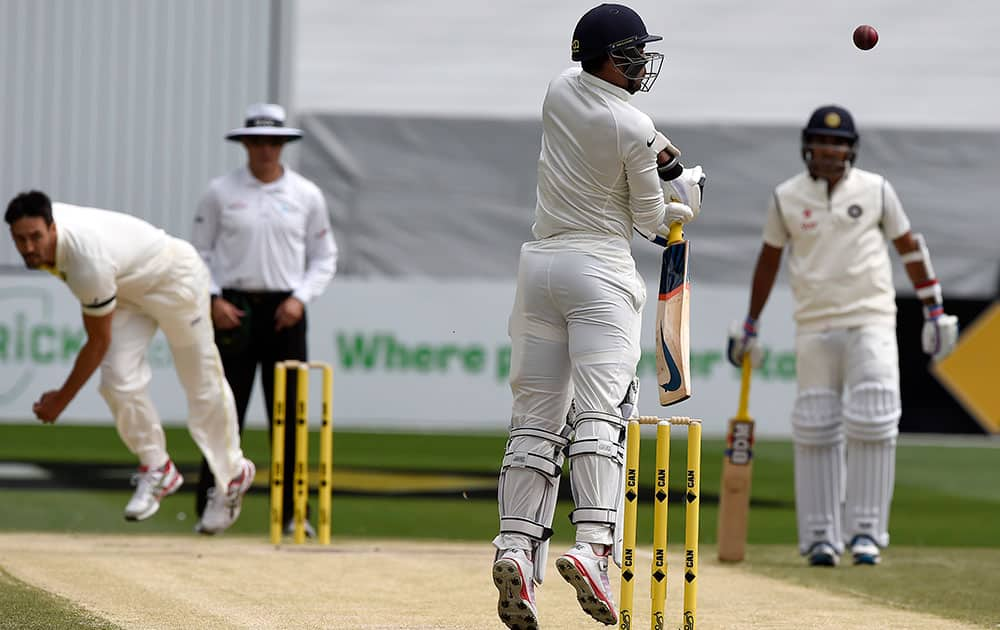 India's Umesh Yadav is stood up by a high delivery from Australia's Mitchell Johnson, left, and is caught behind for no score on fourth day of their third cricket test match in Melbourne, Australia.